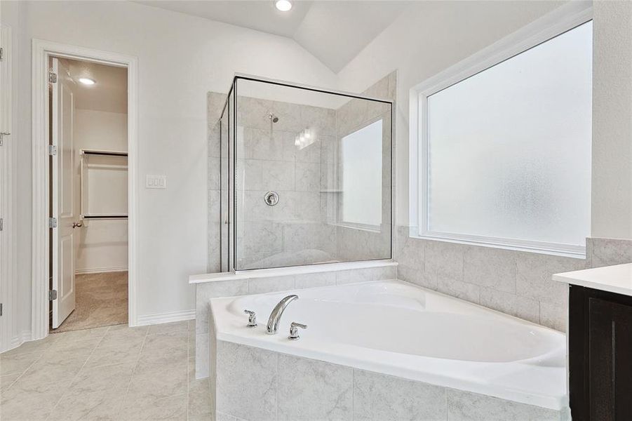 Bathroom with vanity, vaulted ceiling, and independent shower and bath