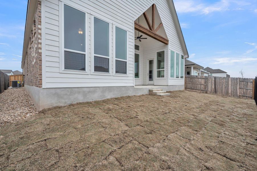 Rear view of property with cooling unit, fence, and ceiling fan Rear view of property with cooling unit, fence, and ceiling fan