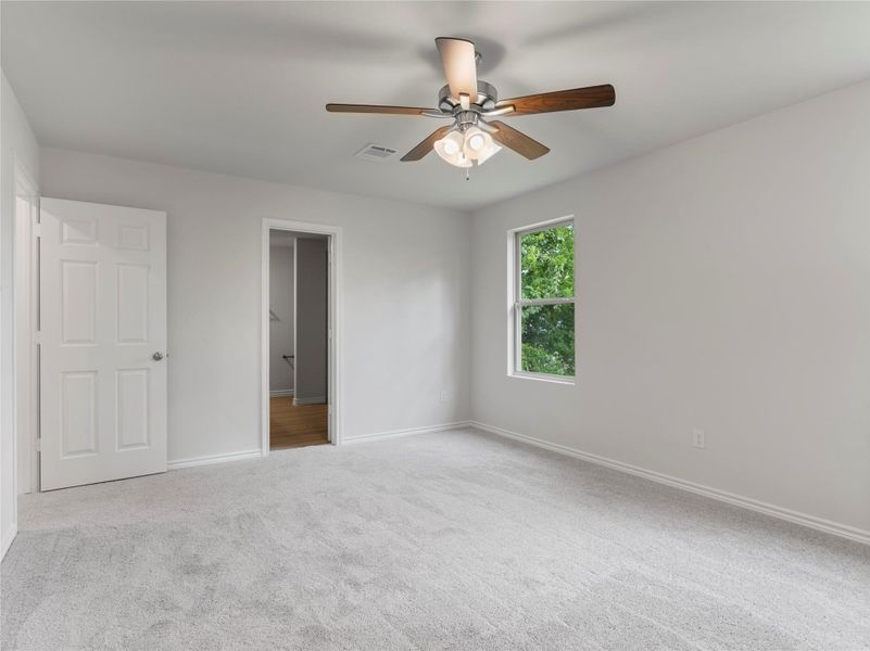 Cozy upstairs bedroom with plush carpeting and natural light.