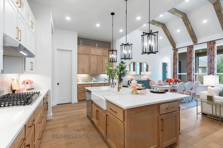 Kitchen with open floor plan, decorative light fixtures, tasteful backsplash, beamed ceiling, and light wood-type flooring