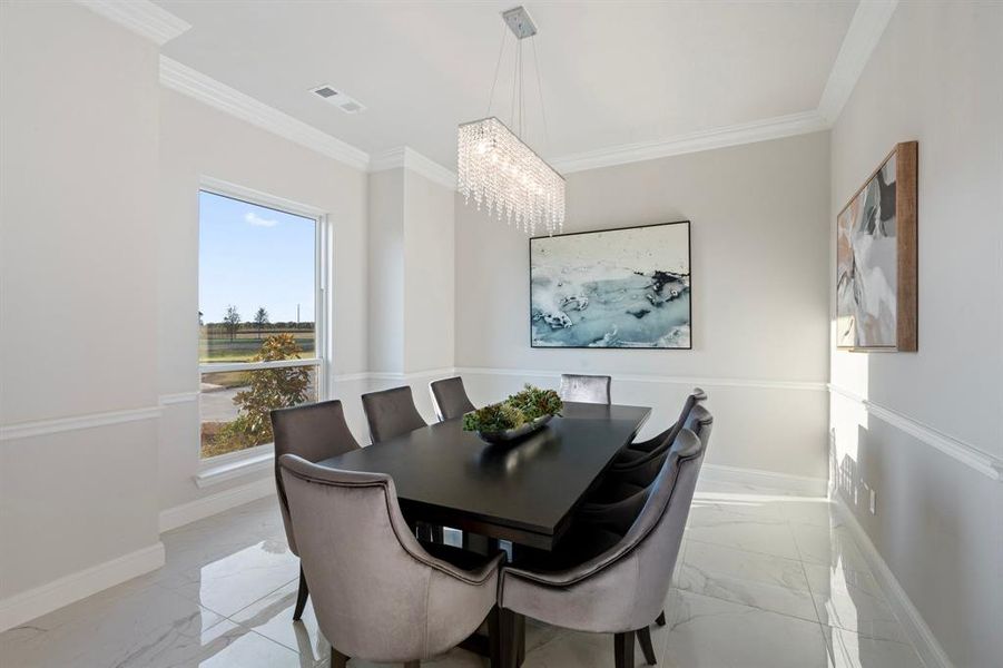 Dining room featuring a chandelier, ornamental molding, and a wealth of natural light