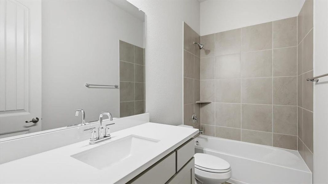 Bathroom featuring a white integrated sink with chrome faucet, light grey vanity cabinetry, and a full-width mirror