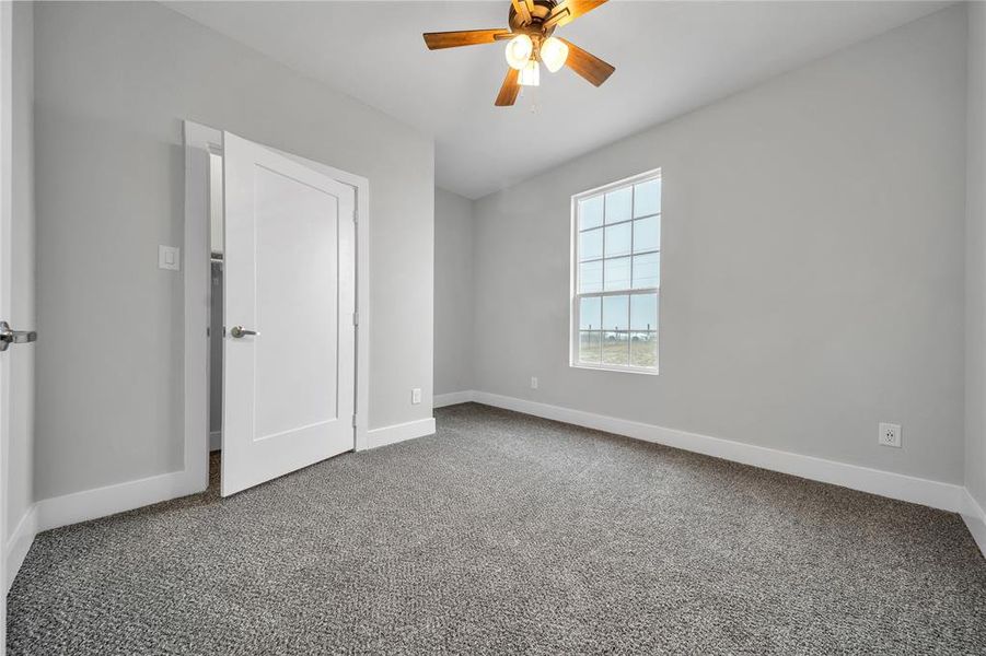 Unfurnished bedroom featuring carpet floors and ceiling fan