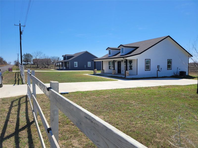 A welcoming front porch enhances this contemporary farmhouse, featuring clean lines and a durable shingle roof. A welcoming front porch enhances this contemporary farmhouse, featuring clean lines and a durable shingle roof.