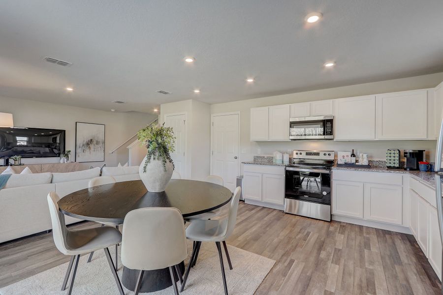 A kitchen with a dining table and chairs.