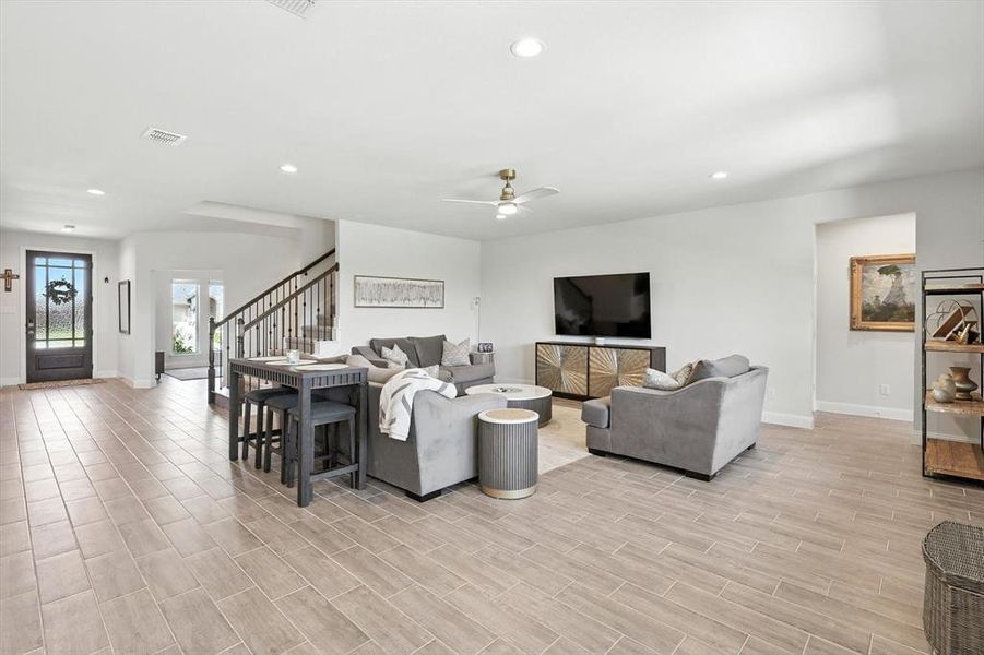 Living area with ceiling fan, stairs, recessed lighting, and light wood-style flooring