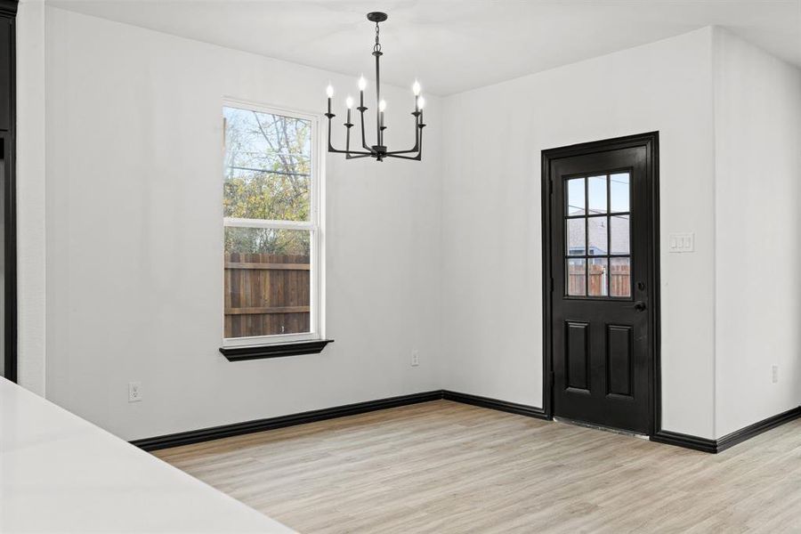 Dinning featuring light wood-type flooring and a chandelier