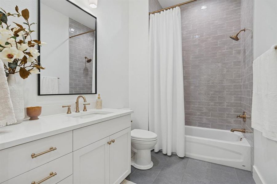 Incredible hallway bathroom with the same perfect finishes: porcelain tile, champagne fixtures, custom cabinets and tons of storage. No detail missed!