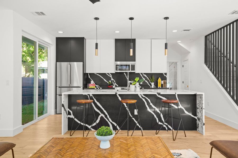 Kitchen featuring modern cabinets, tasteful backsplash, light stone countertops, light wood finished floors, and recessed lighting Kitchen featuring modern cabinets, tasteful backsplash, light stone countertops, light wood finished floors, and recessed lighting