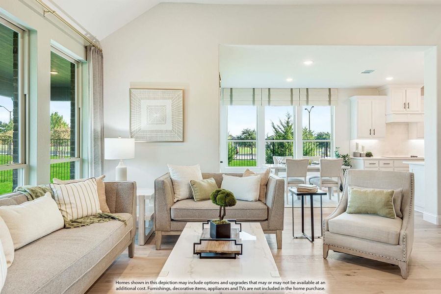 Open living room with neutral furniture, hardwood floors, and large windows overlooking a patio