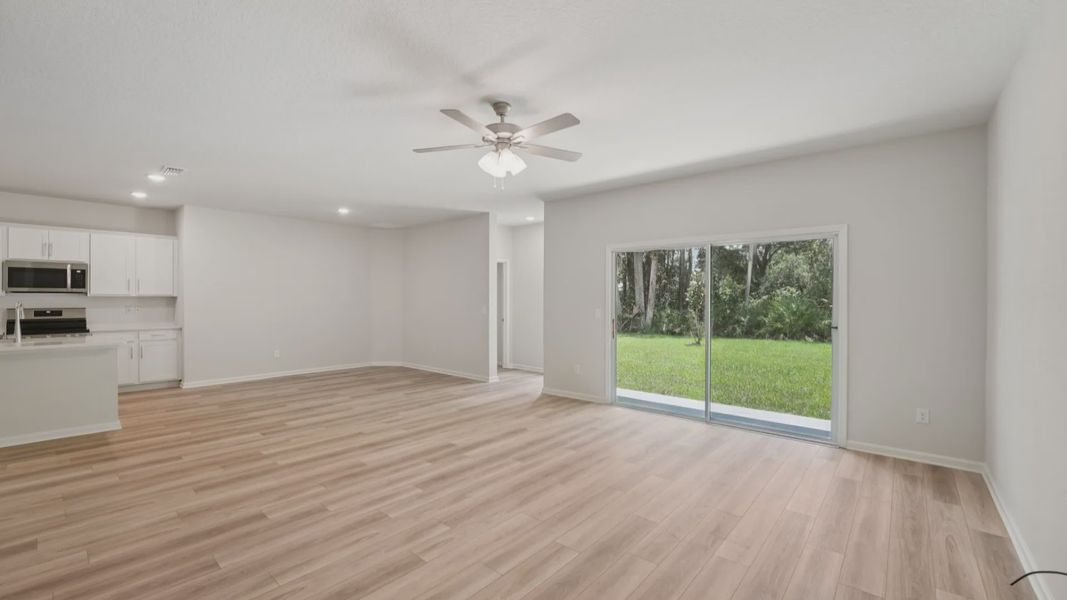 Elegant vinyl plank floors in open living area, Palm Coast. Seamless indoor-outdoor flow with lush views.