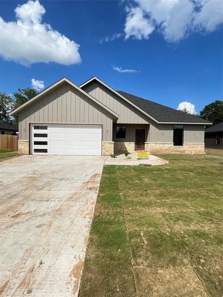 View of front facade featuring a garage and a front yard