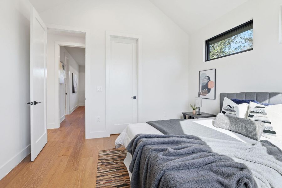 Bedroom with lofted ceiling and light wood-style flooring Bedroom with lofted ceiling and light wood-style flooring