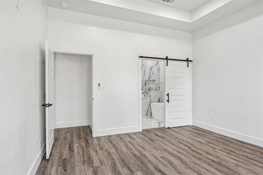 Room with wood-finish flooring and a tray ceiling