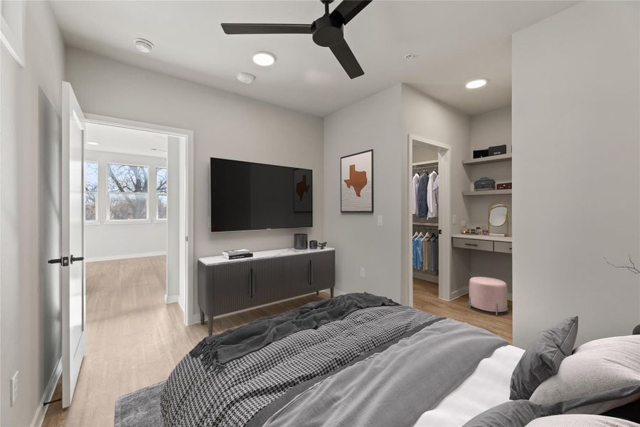 Bedroom featuring light wood finished floors, a walk in closet, baseboards, recessed lighting, and a ceiling fan
