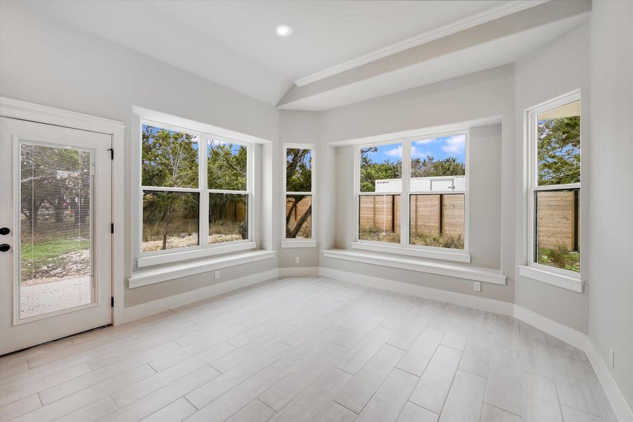 Unfurnished sunroom featuring lofted ceiling