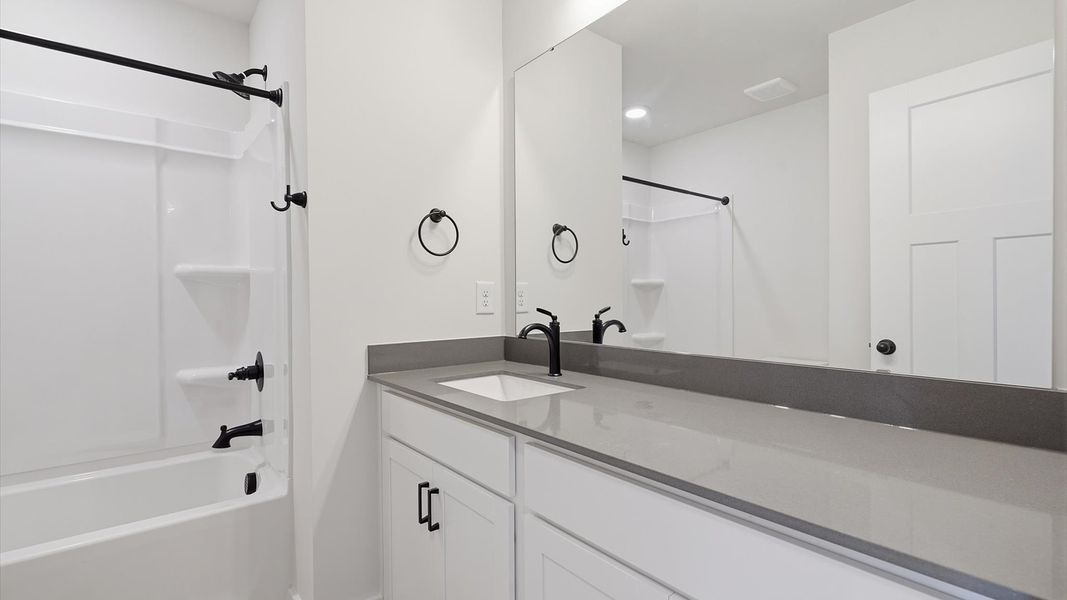 Top-notch bathroom with current fixtures, tasteful materials, and elevated charm by DRB Homes Top-notch bathroom with current fixtures, tasteful materials, and elevated charm by DRB Homes