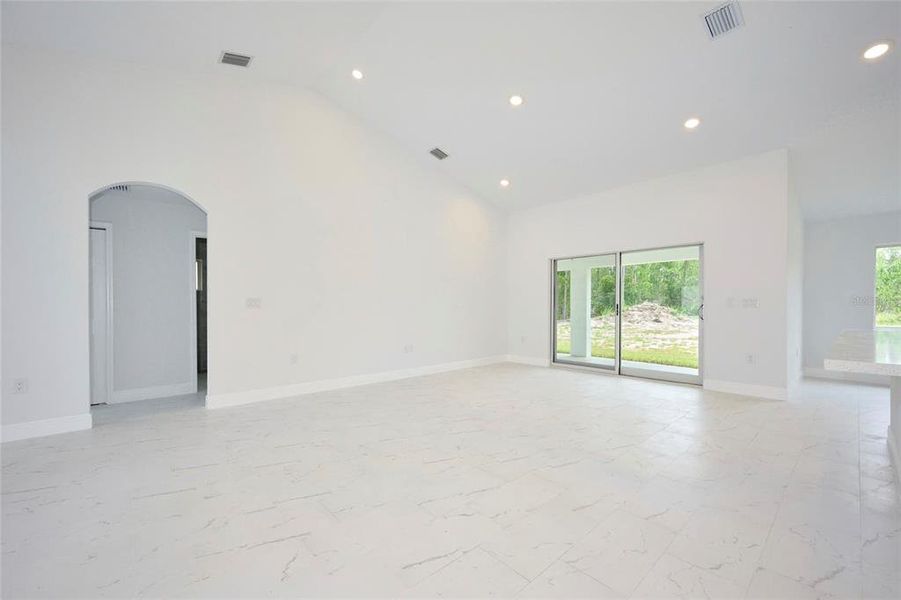 Great room with sliders that lead out to under-truss lanai area.  Doorway to left in picture lead to secondary bedrooms and guest bath.