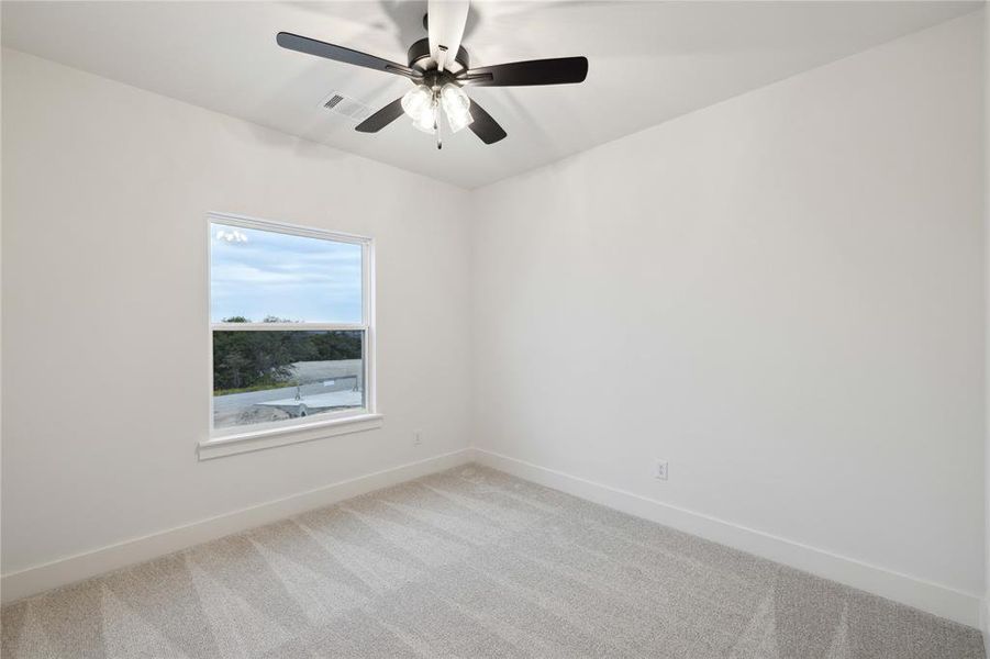 Carpeted spare room featuring ceiling fan