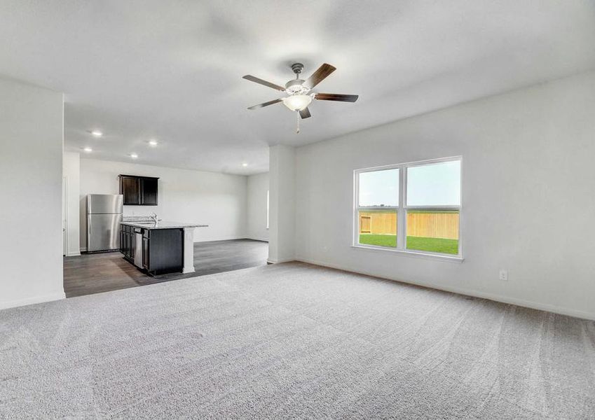 Rio great room with ceiling fan, light gray carpets, and white on white walls