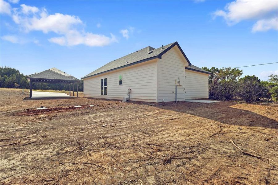 View of side of property featuring roof with shingles and a patio View of side of property featuring roof with shingles and a patio