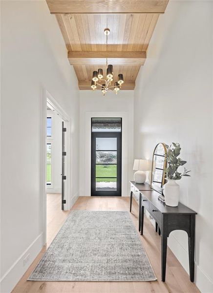 Entryway featuring a wood ceiling with exposed beams, a chandelier, and light wood-style floors