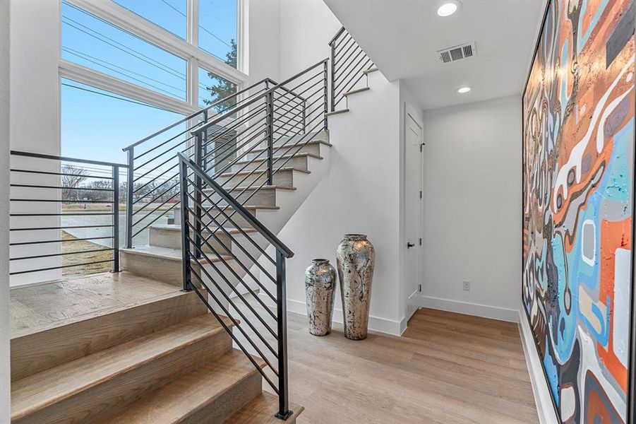 Staircase with light hardwood / wood-style flooring