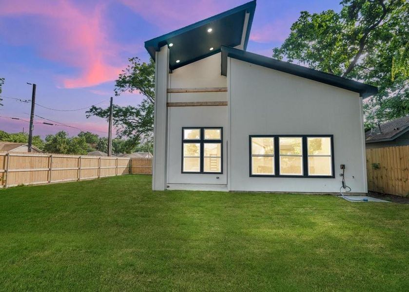 Back house at dusk with a lawn