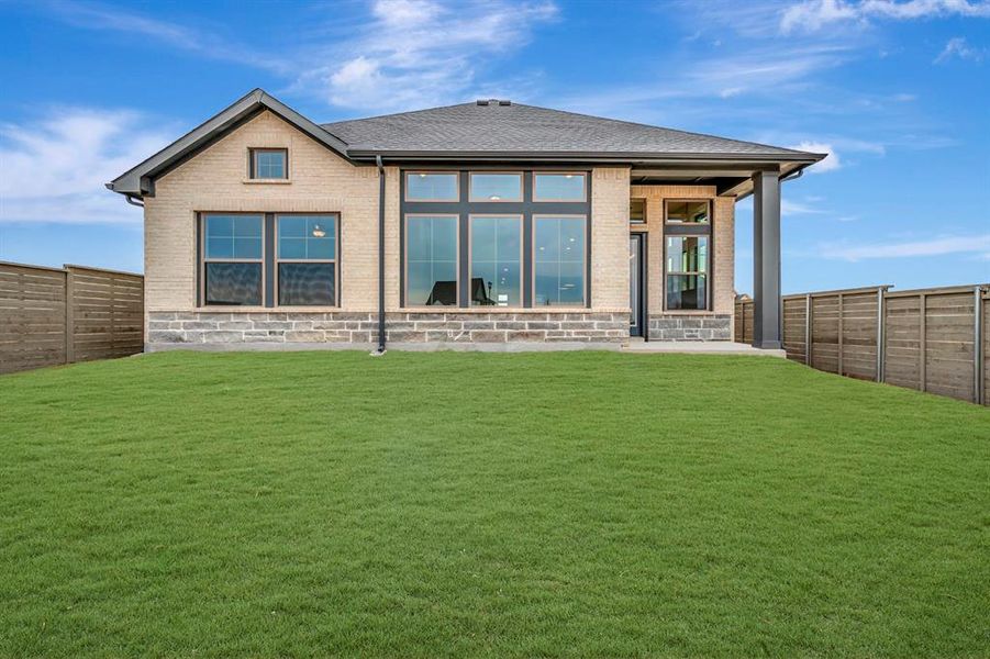 Rear view of house featuring a fenced backyard, a patio area, brick siding, and roof with shingles