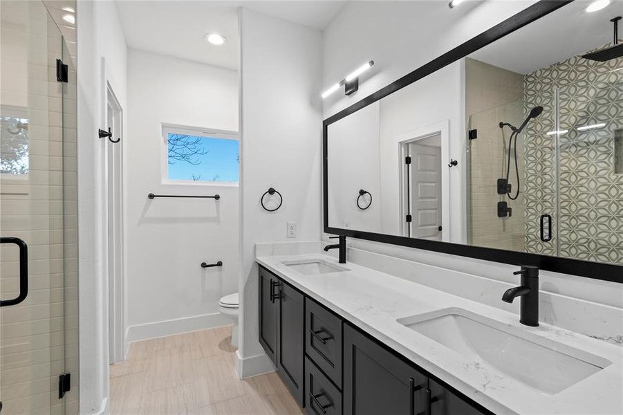 Bathroom with vanity, an enclosed shower, and toilet