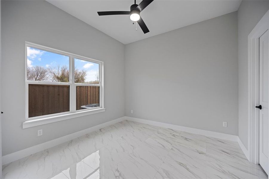 Unfurnished room with baseboards, marble finish floor, and ceiling fan