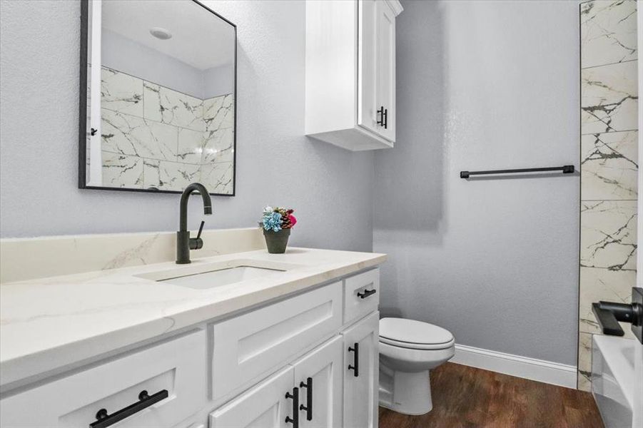 Bathroom featuring toilet, vanity, and hardwood / wood-style flooring