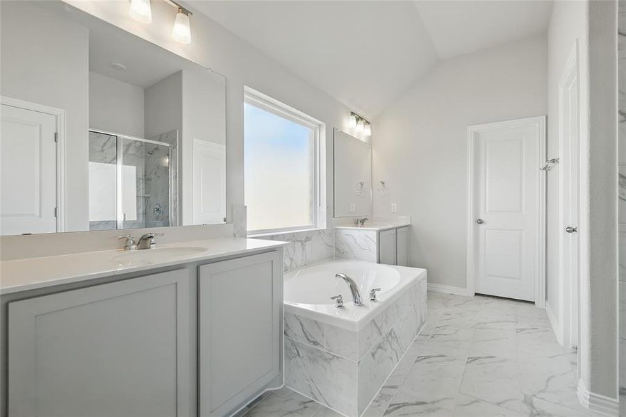 Bathroom with marble finish flooring, vaulted ceiling, a marble finish shower, a bath, and vanity Bathroom with marble finish flooring, vaulted ceiling, a marble finish shower, a bath, and vanity