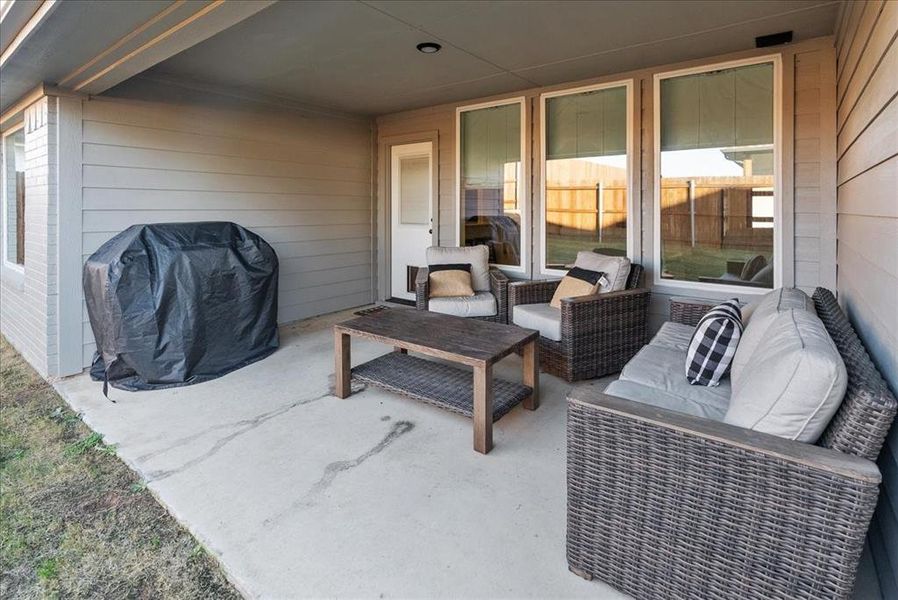 View of patio with an outdoor hangout area and a grill