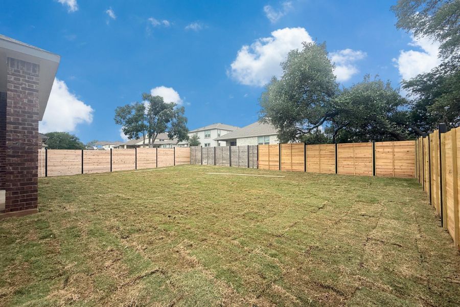 Expansive backyard with a newly installed wood fence Expansive backyard with a newly installed wood fence