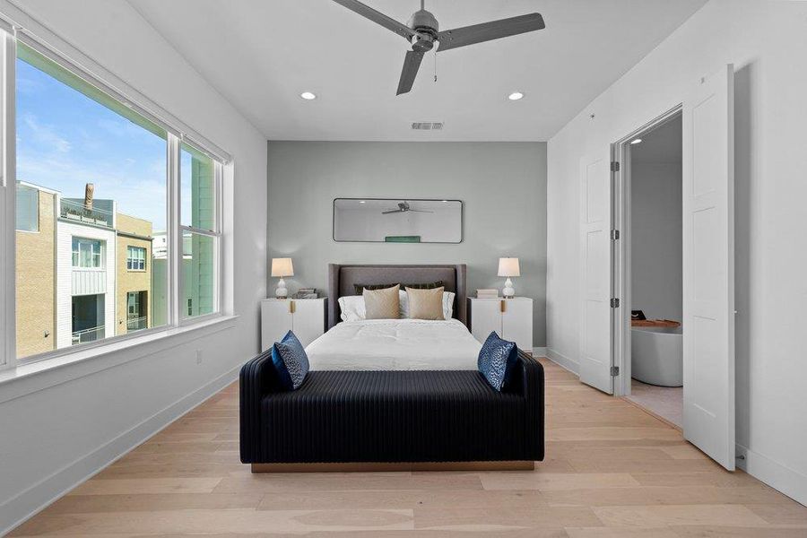 Hardwood floors and massive windows define this peaceful bedroom with an ensuite bath. Hardwood floors and massive windows define this peaceful bedroom with an ensuite bath.