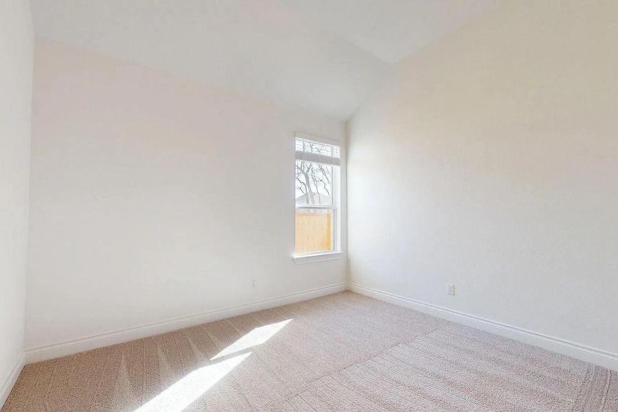 This room features light-colored carpeted flooring and white walls, creating a bright and airy atmosphere