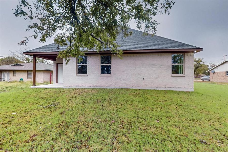 Back of property featuring a patio and a yard