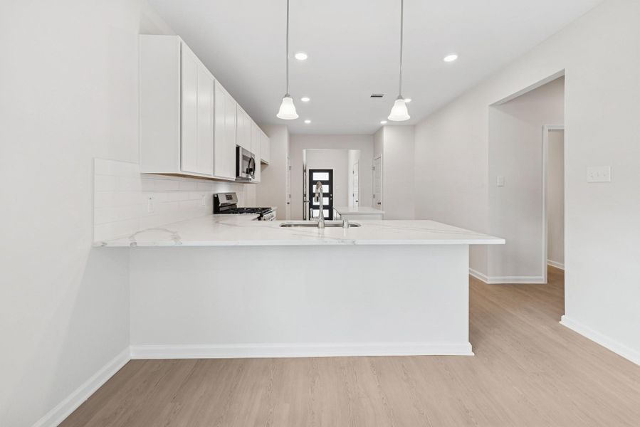 The Cardinal II- Dining Area into Kitchen. Photos of home shown are for illustration only; actual features, colors, and upgrades may vary.