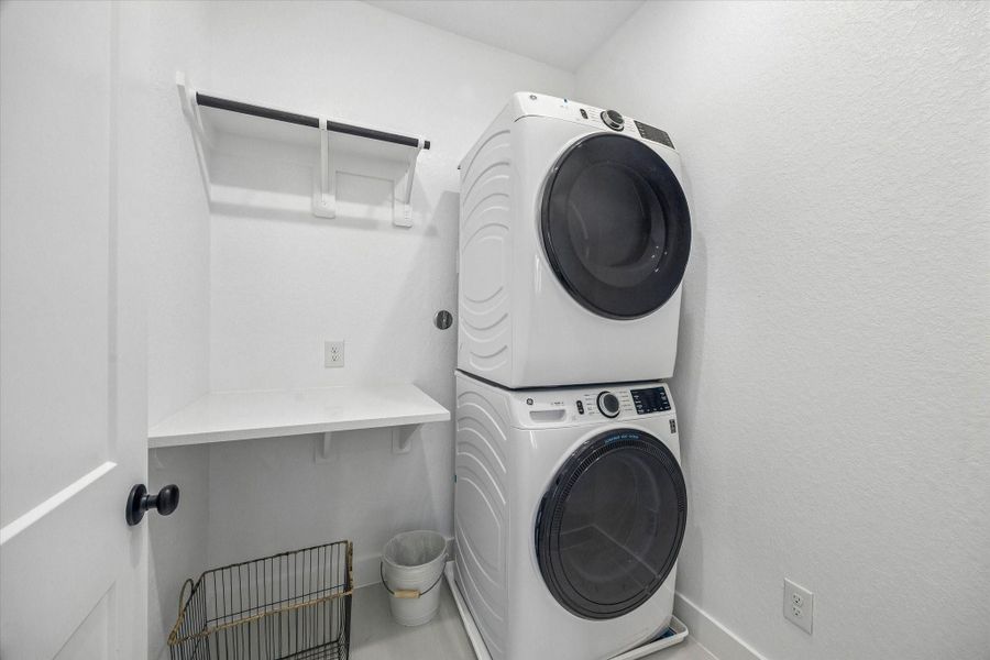 Conveniently located just outside the primary bedroom, the second-floor laundry room features a hanging rack and folding table for added functionality and ease.
