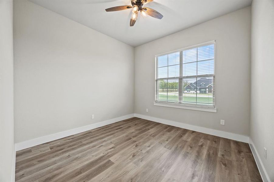 Empty room with light wood-style flooring and a ceiling fan Empty room with light wood-style flooring and a ceiling fan