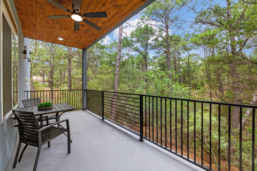 An inviting covered deck offers forest views and a relaxing outdoor retreat.