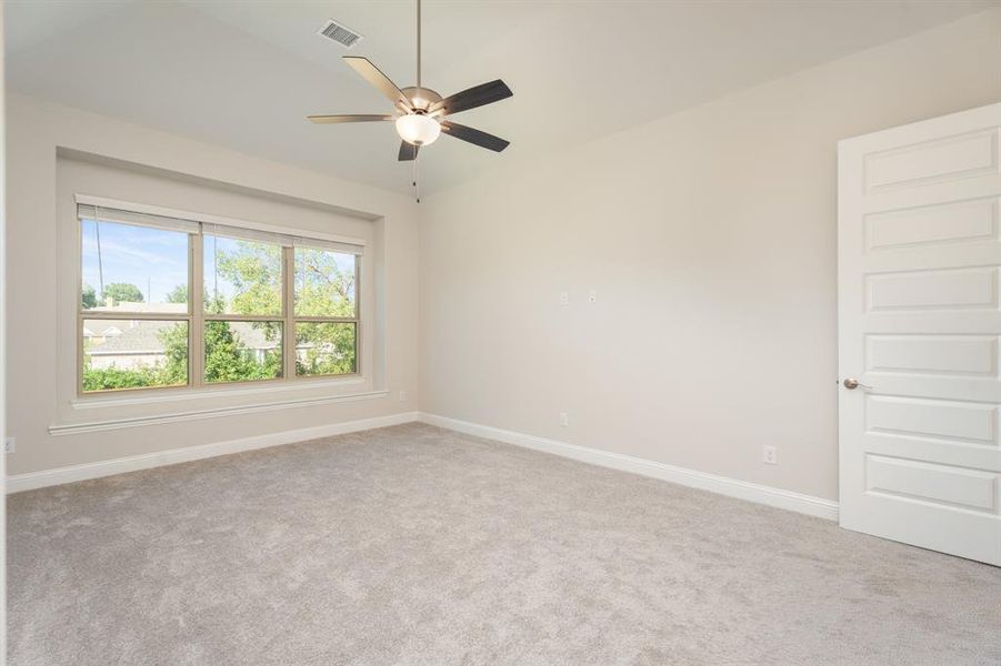 Empty room featuring light colored carpet and ceiling fan