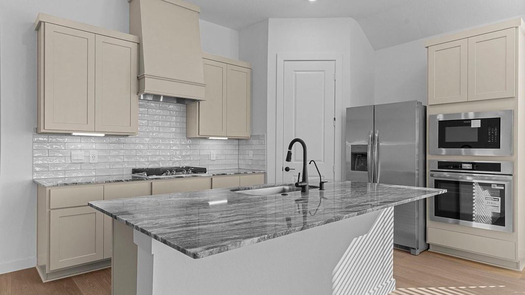 An open concept kitchen with an island with bar seating and access to the living and dining areas.