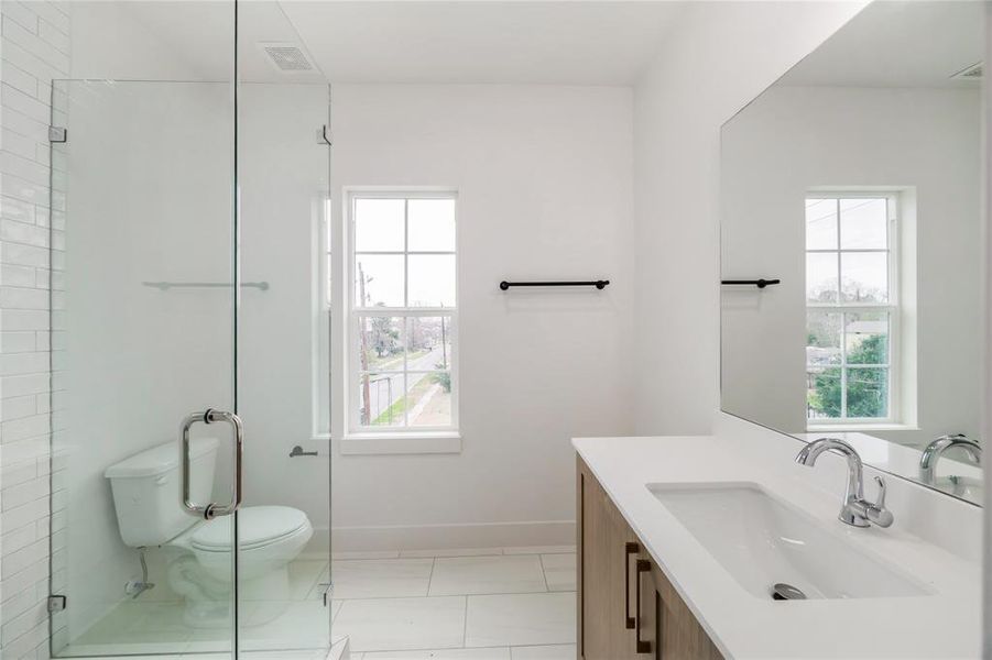 Bright and airy third-floor bathroom with modern fixtures and a spacious glass shower.