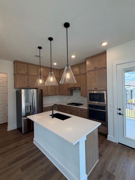 Modern kitchen features a substantial island and sleek stainless steel appliances, ready for culinary endeavors. Modern kitchen features a substantial island and sleek stainless steel appliances, ready for culinary endeavors.