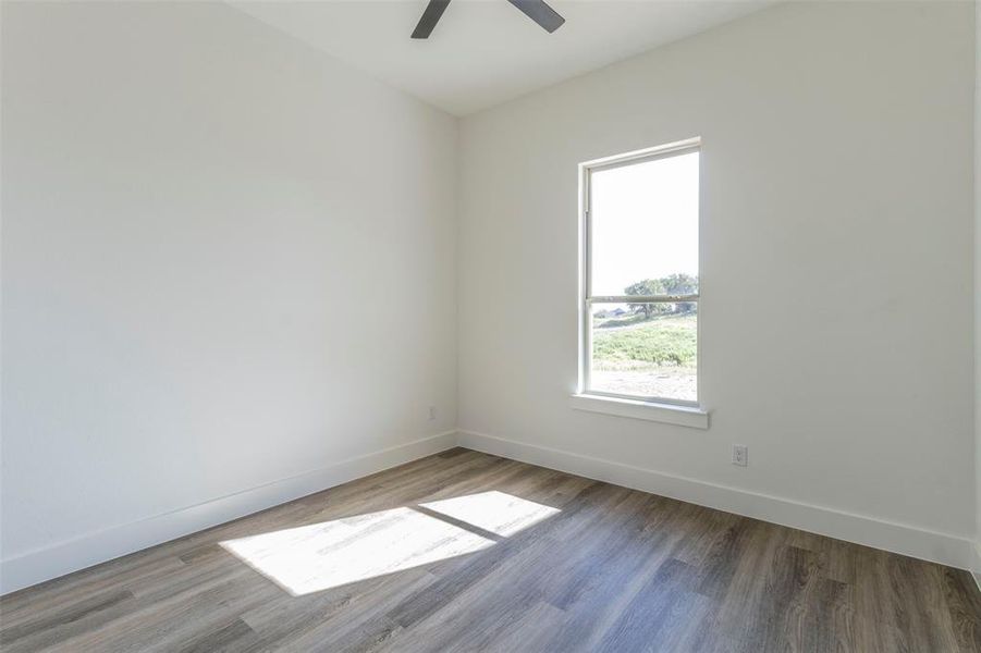 Unfurnished room with ceiling fan, hardwood / wood-style flooring, and plenty of natural light