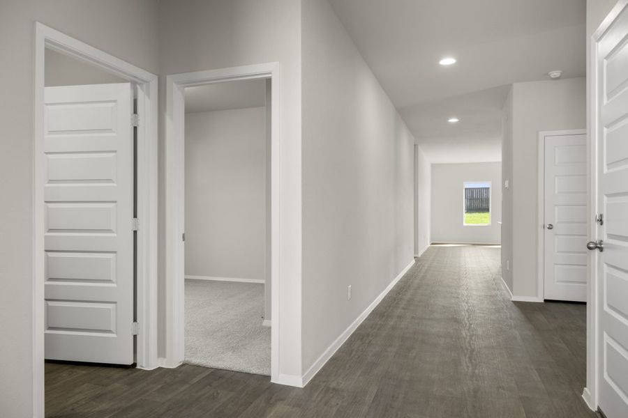 Image of home foyer with wood-look floors, white walls, window and multiple doorways