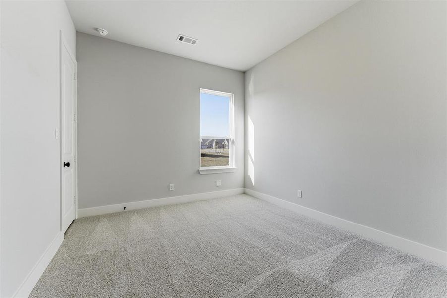 Spare room featuring light colored carpet and baseboards