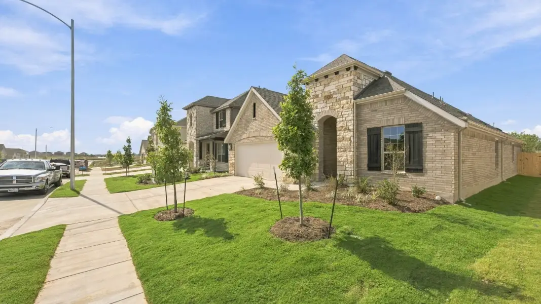Front exterior of a new home in Carillon, Manor, TX, highlighting curb appeal (Image 21).